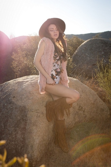 A modelo Centerfold Drew Catherine desenhou tiras nas suas botas para a Playboy no meio de rochas