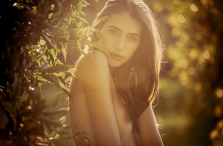 Centerfold model Katrine Pirs poseert naakt naast een sinaasappelboom