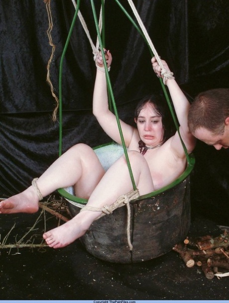 Överviktig kvinnlig sexslav hålls fast i en korg under nålspel