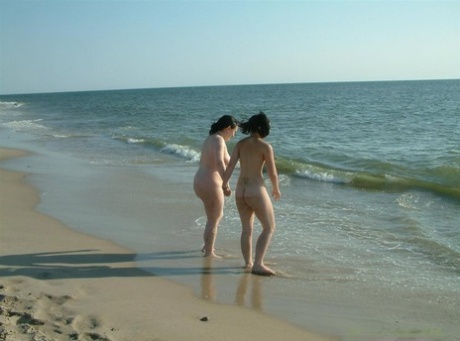 Naked girl is tied up with rope by her lesbian lover as the surf comes in