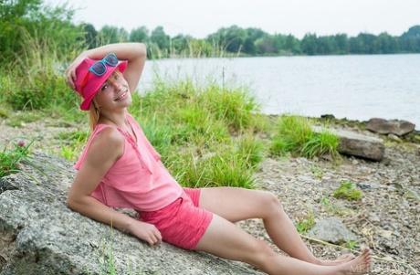 De kleine roodharige Shannan deelt haar roze tienerkutje op een rotsachtige kustlijn