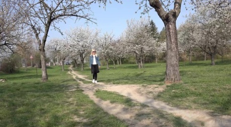 Blonde girl Debora takes an urgent pee on a dirt path through an orchard