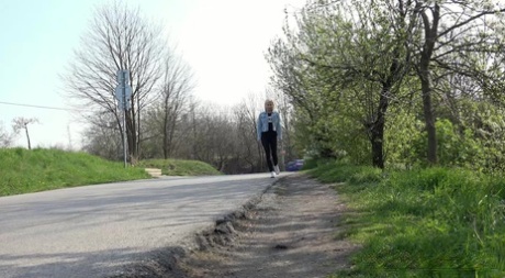 Mooie blonde Debora trekt zwarte legging naar beneden om naast de weg te plassen