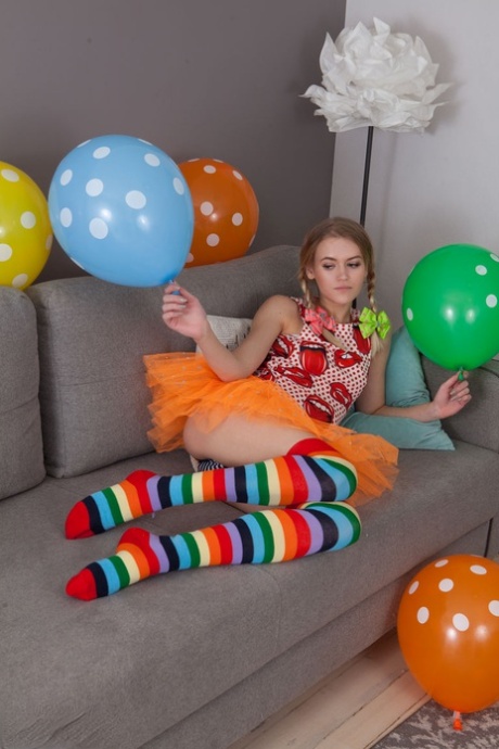 Die schlanke Teenagerin Lili zieht ihre Kleider und langen Socken aus und posiert nackt inmitten von Luftballons