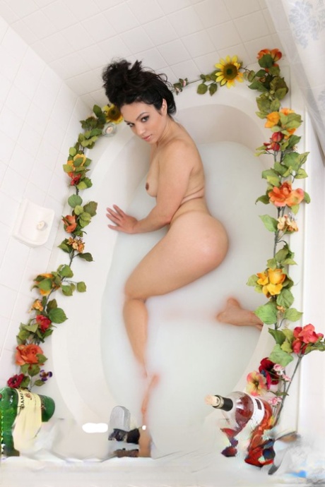 Dark haired teen Tia models in the nude while taking a bath