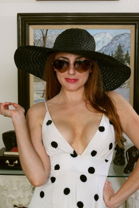 Over 30 redhead Stephanie Swan sheds a long dress to pose naked in a sunhat