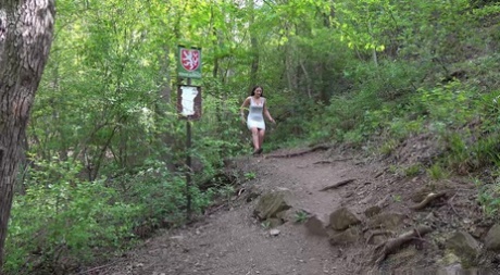 Den kaukasiske jenta Nicolette Noir pisser sårt tiltrengt på en sti i skogen.