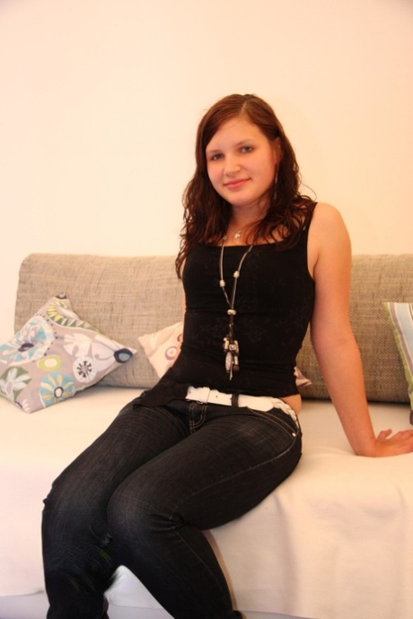 Menina de aspecto jovem, com mamas de pijama, faz a sua estreia como modelo nua no sofá.