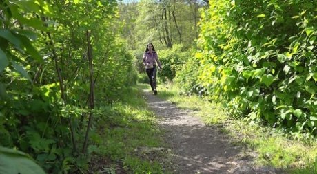 Den vackra flickan Isabel Dark drar ner byxorna för att kissa på en stig i skogen