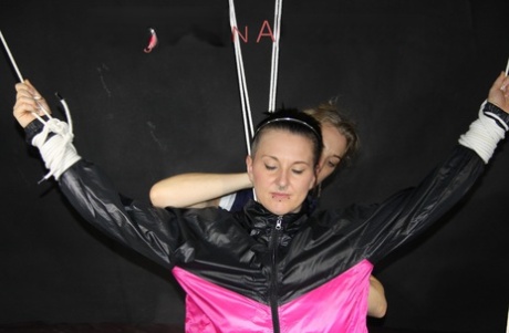 Restrained white girl is fitted with a gag in nylon rain wear