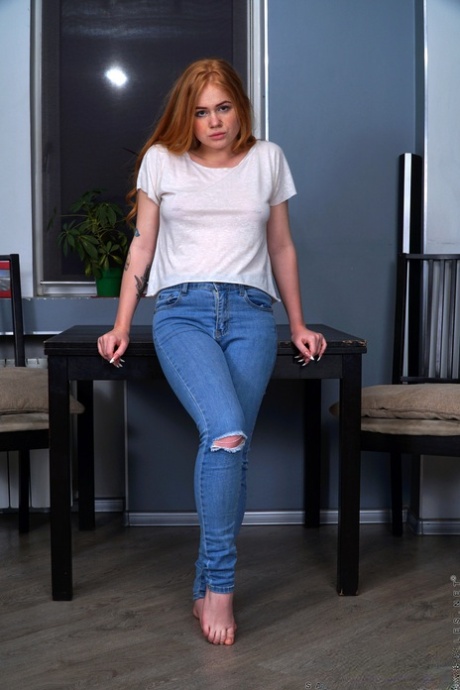 Hot redhead Samanta Simpson peels off ripped jeans on her way to posing naked