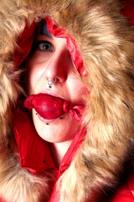 Chica blanca con el pelo teñido y piercings está atada con ropa de invierno