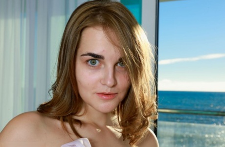 Teenage-solopigen Olga Zz tager sig til sin runde røv, mens hun står model helt nøgen