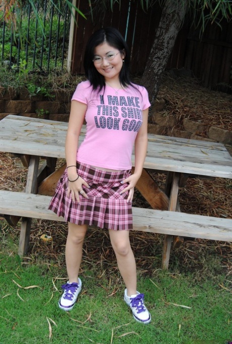 La adolescente asiática Chiyo se sube la falda para mostrar su culo y su coño en una mesa de picnic