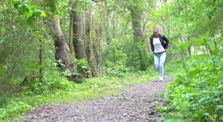 Solo meisje Naomi Bennet trekt haar jeans naar beneden om te pissen op een pad in het bos