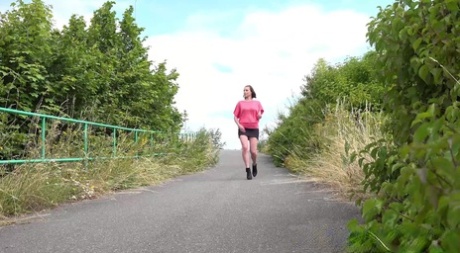 Kaukasisch meisje Vicoria Daniels pisses op een verharde weg terwijl uit voor een wandeling