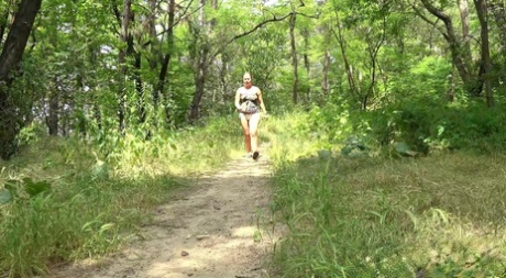 Natural blonde Licky Lex takes a piss while jogging on a dirt path