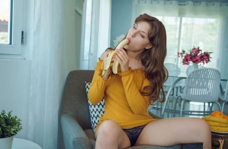 Красивый подросток Сатин Стоун ест банан, прежде чем раздеться для мастурбации