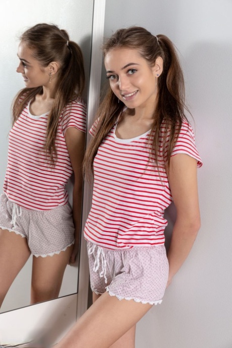 Dünner Teenager Angelina zieht sich auf ihrem Bett vor einem Spiegel aus