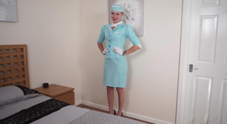 Blond stewardesa zdejmuje mundur, chodząc nago w pończochach