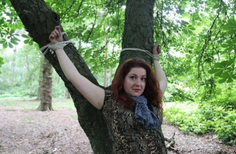 Pelirroja completamente vestida es atada a un árbol en el bosque y olvidada