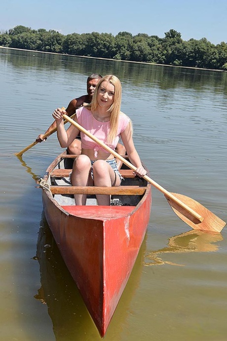 A jovem loira e o amigo dela vão de canoa para uma ilha para foder na natureza.