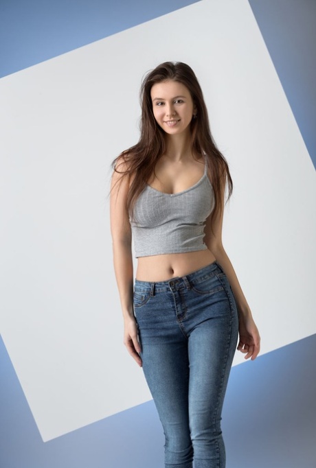 Fina tonåringen Alisa I befriar sin vackra kropp från en midjekort skjorta och blå jeans