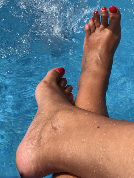 La femme mûre Sweet Susi trempe ses ongles de pied peints dans une piscine