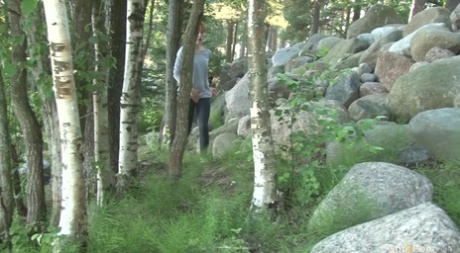 Ira, pelirroja natural, mea con urgencia sobre unas rocas en el bosque