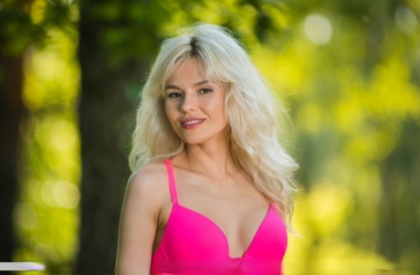 Zarina A, blonde platine, enlève son soutien-gorge et sa culotte roses pour poser nue dans une tente.