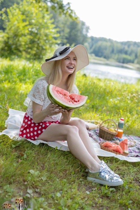 Schattige tiener Sophie is helemaal naakt terwijl ze een watermeloen eet in een weiland