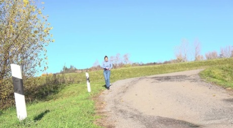 White girl Antonia Sainz takes a piss on a gravel road during the day