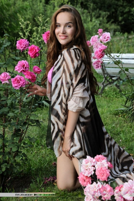 La bella teenager Eva Jolie libera il suo corpo da bikini in un giardino di rose