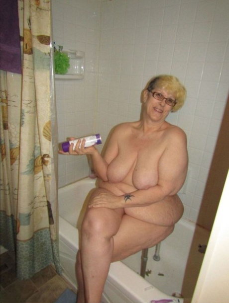 La grassa nonna Bunny Gram si depila le gambe sul lato della vasca da bagno