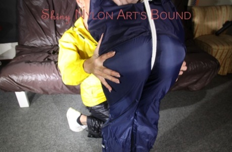 Sandra siendo atada y amordazada por Stella en nylon brillante Rainwear crotchrope