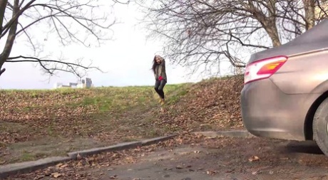 Kaukasisch meisje Esperansa doet een dringend plasje achter een geparkeerde auto