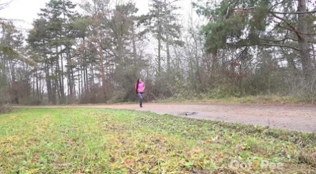 Wit meisje Lara Fox trekt haar legging naar beneden om te plassen op een landweggetje