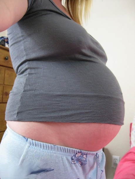 Gravid tjej tar självbilder medan hon klär av sig naken för att onanera