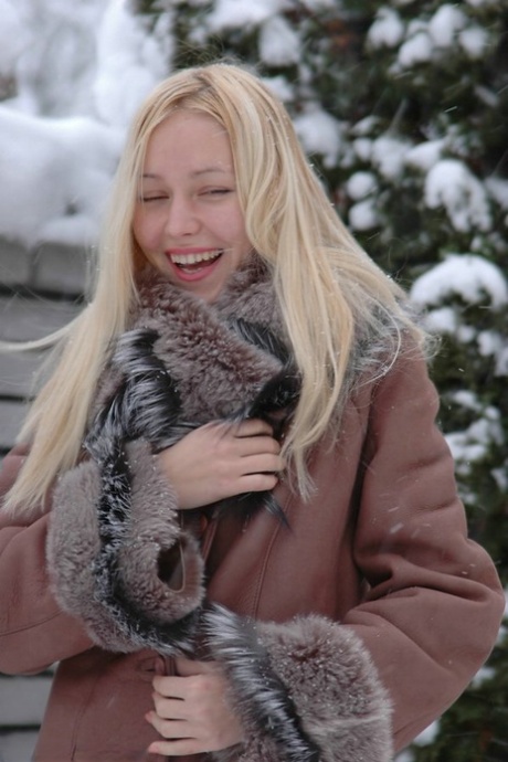 Une blonde naturelle exhibe son beau corps sur un sol enneigé