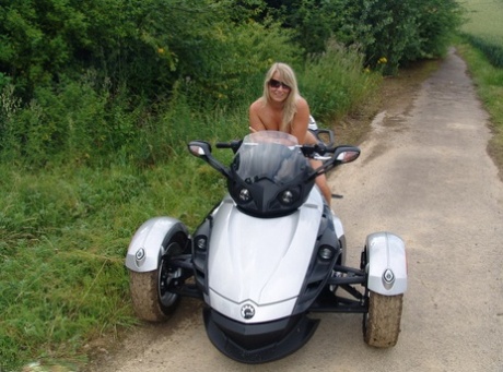 Blonde Sweet Susi van middelbare leeftijd rijdt naakt op een motor met drie wielen