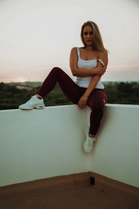 La rubia Candice Collyer se quita los leggings negros para desnudarse en un balcón