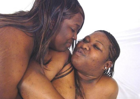 Grote zwarte vrouwen tonen hun borsten terwijl ze met elkaar worstelen