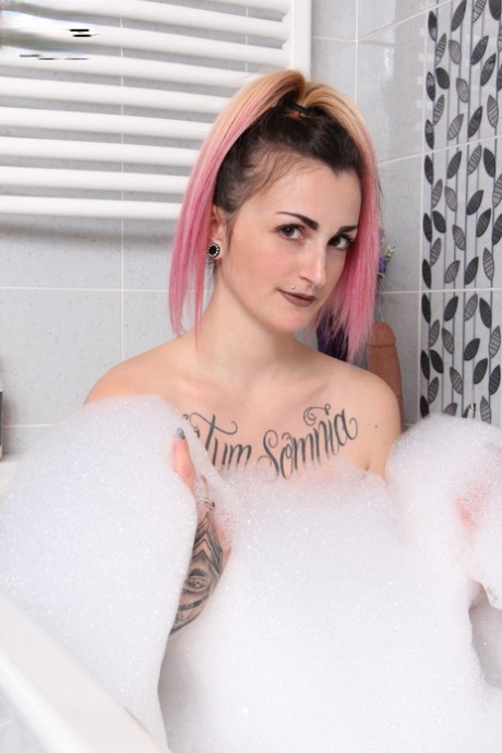 La ragazza tatuata Medusa Blonde gioca con un dildo mentre fa il bagno in collant