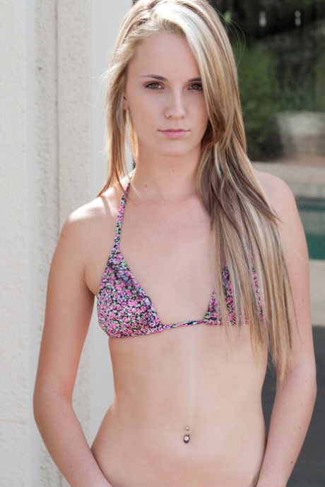 Skinny blonde does away with her bikini to get naked in a backyard