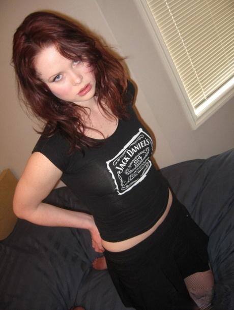 A adolescente ruiva Lana goza numa cama com uma T-shirt da Jack Daniels