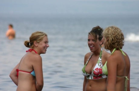Sammlung von Amateurmädchen, die in Bikinis am Strand abhängen