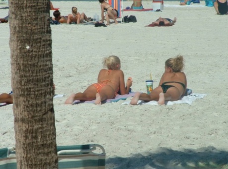 Candid non-naakt actie van meisjes in bikini die stranddingen doen