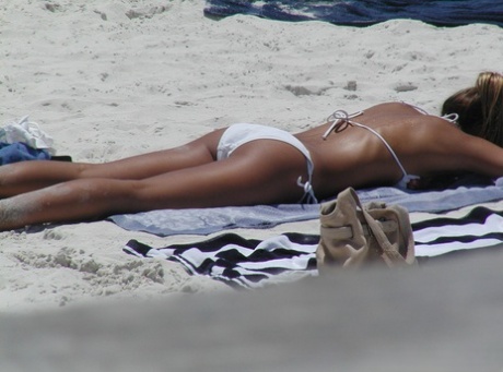 Ação sincera de raparigas amadoras a apanhar banhos de sol em biquíni numa praia