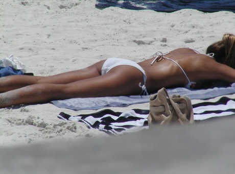 Candid actie van amateur meisjes genieten van de stralen op een strand in bikini