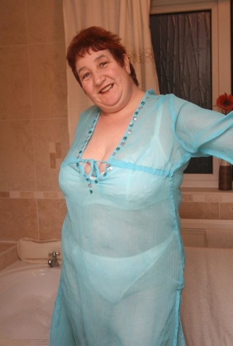 A ruiva nan Kinky Carol estaciona a sua figura gorda numa banheira, completamente vestida